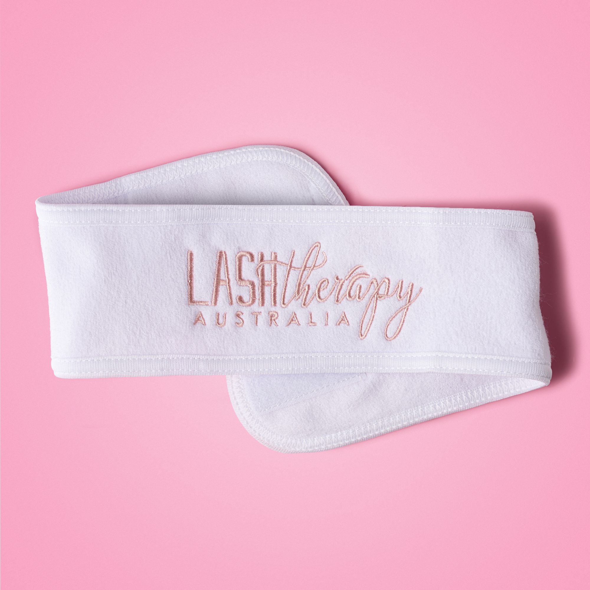 White headband with 'Lash Therapy Australia' text on a pink background