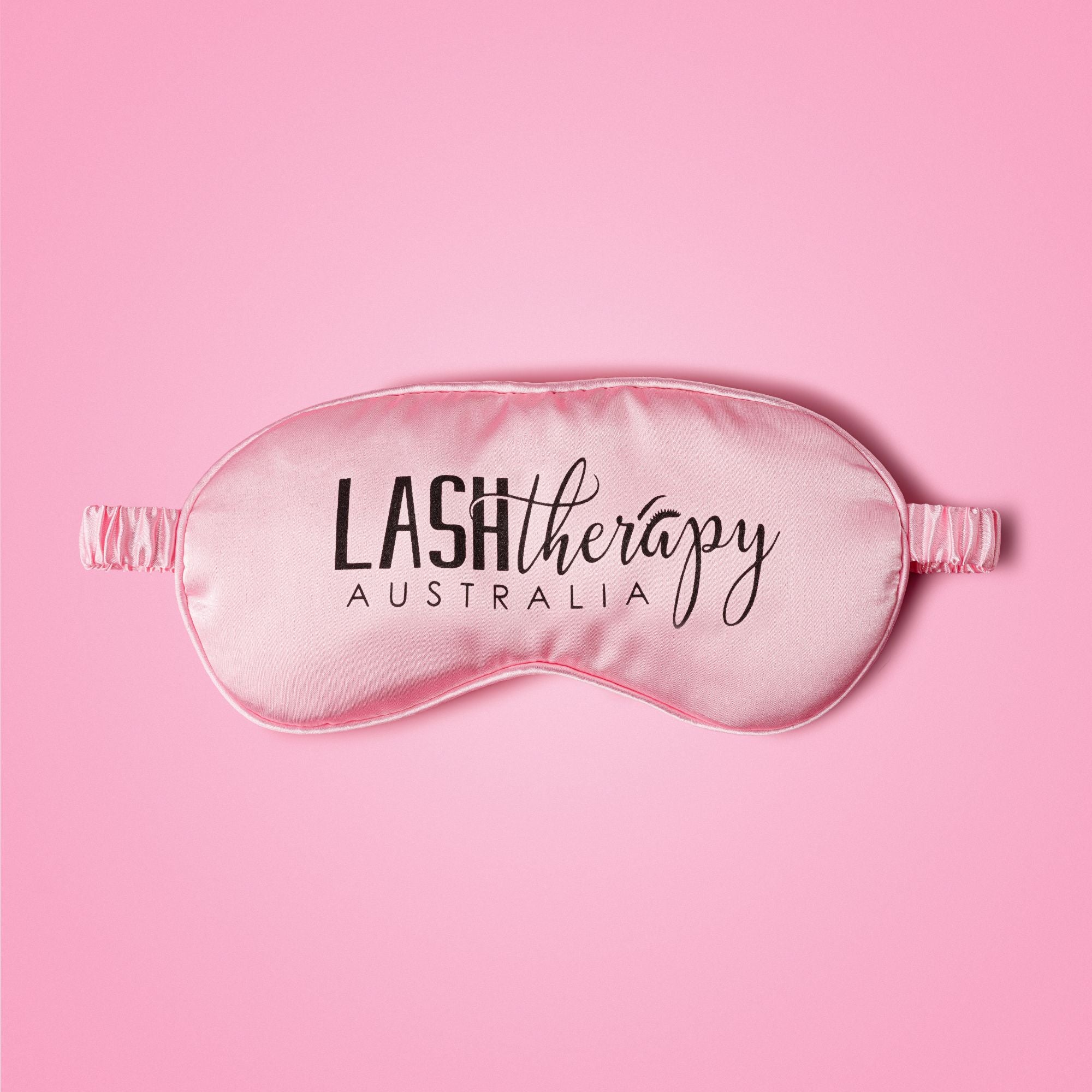 Pink sleep mask with 'Lash Therapy Australia' text on a pink background